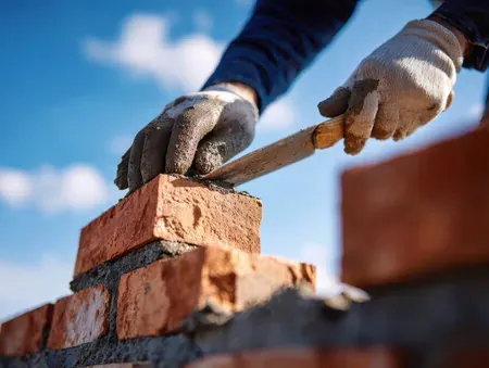Mason setting masonry units in mortar for a Santa Clarita yard wall